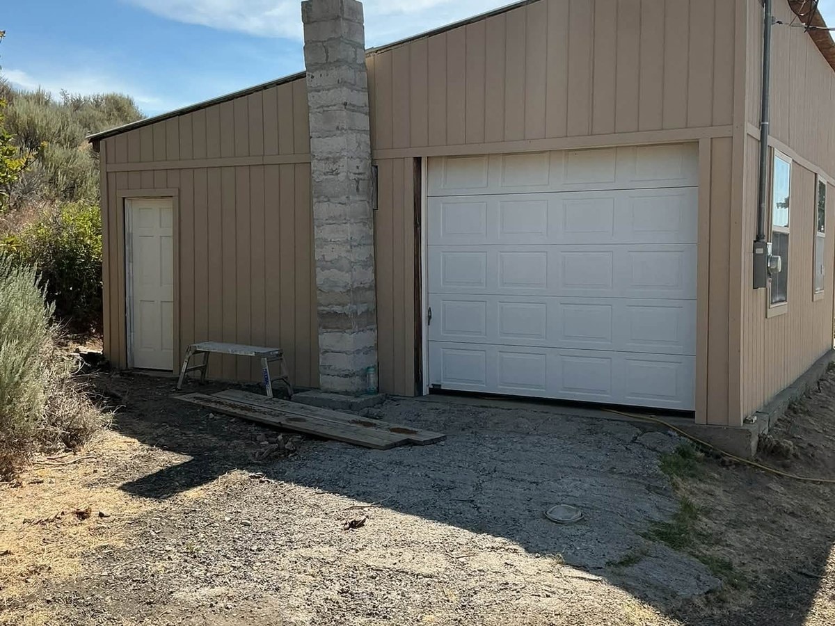 The same garage after new tan steel siding went on