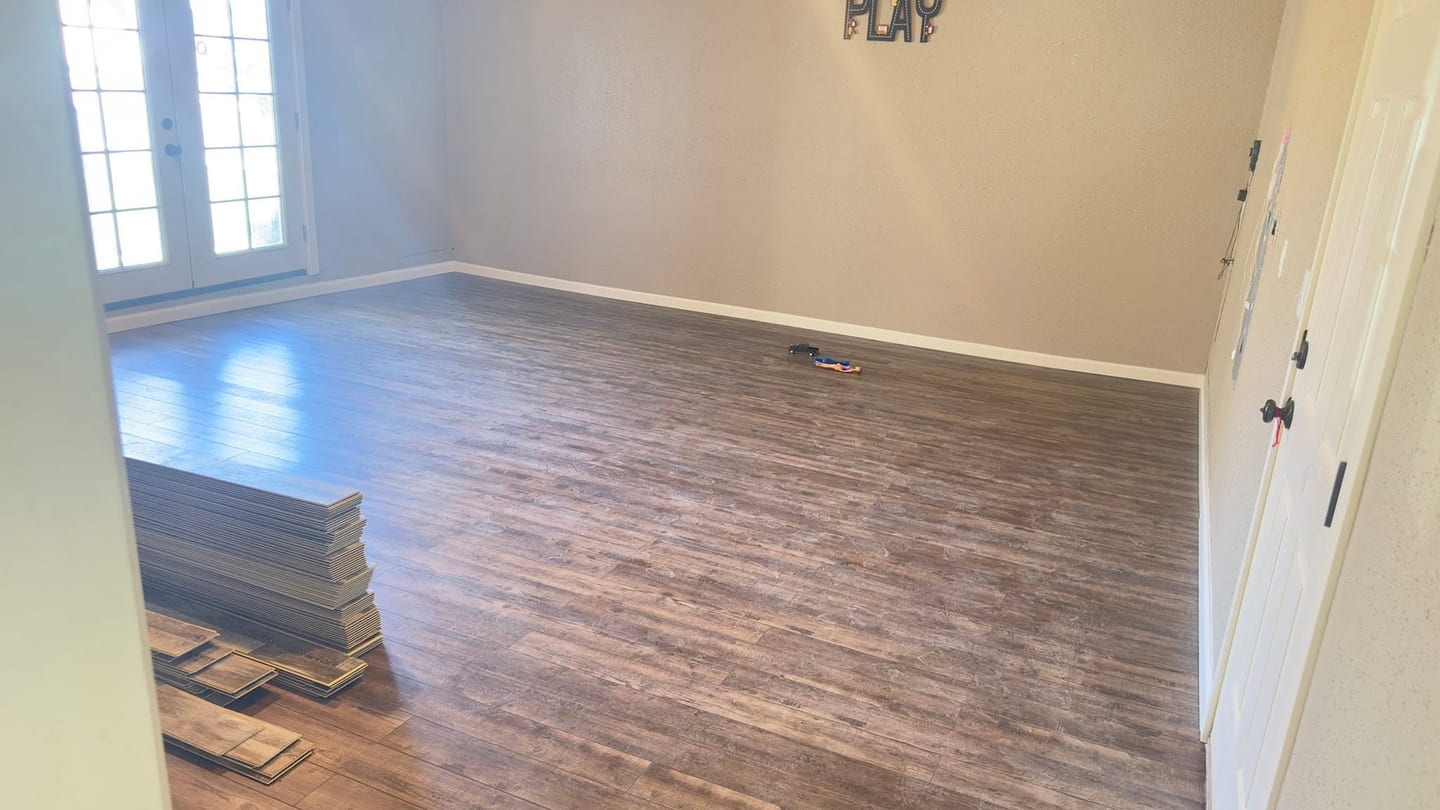 A room with newly laid plank flooring part way through the run