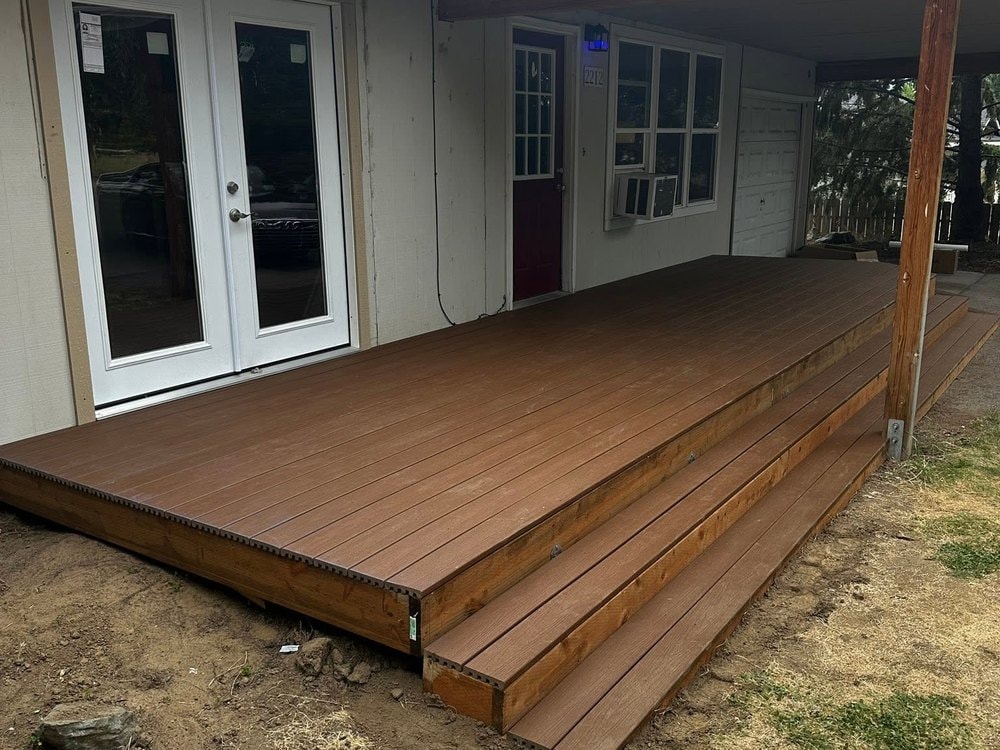 The completed deck seen from the yard, with steps wrapping the open corner