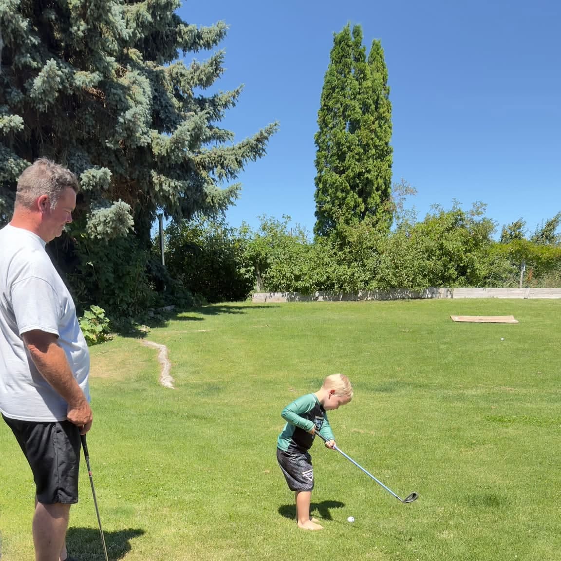 TJ and his son playing backyard golf on a day off