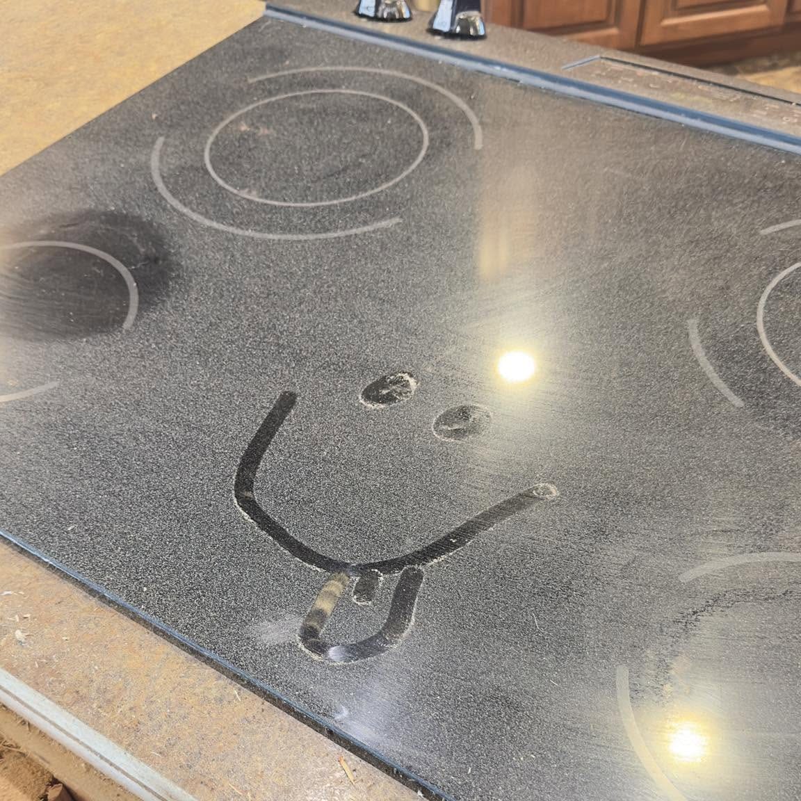A smiley face drawn in the dust on a countertop