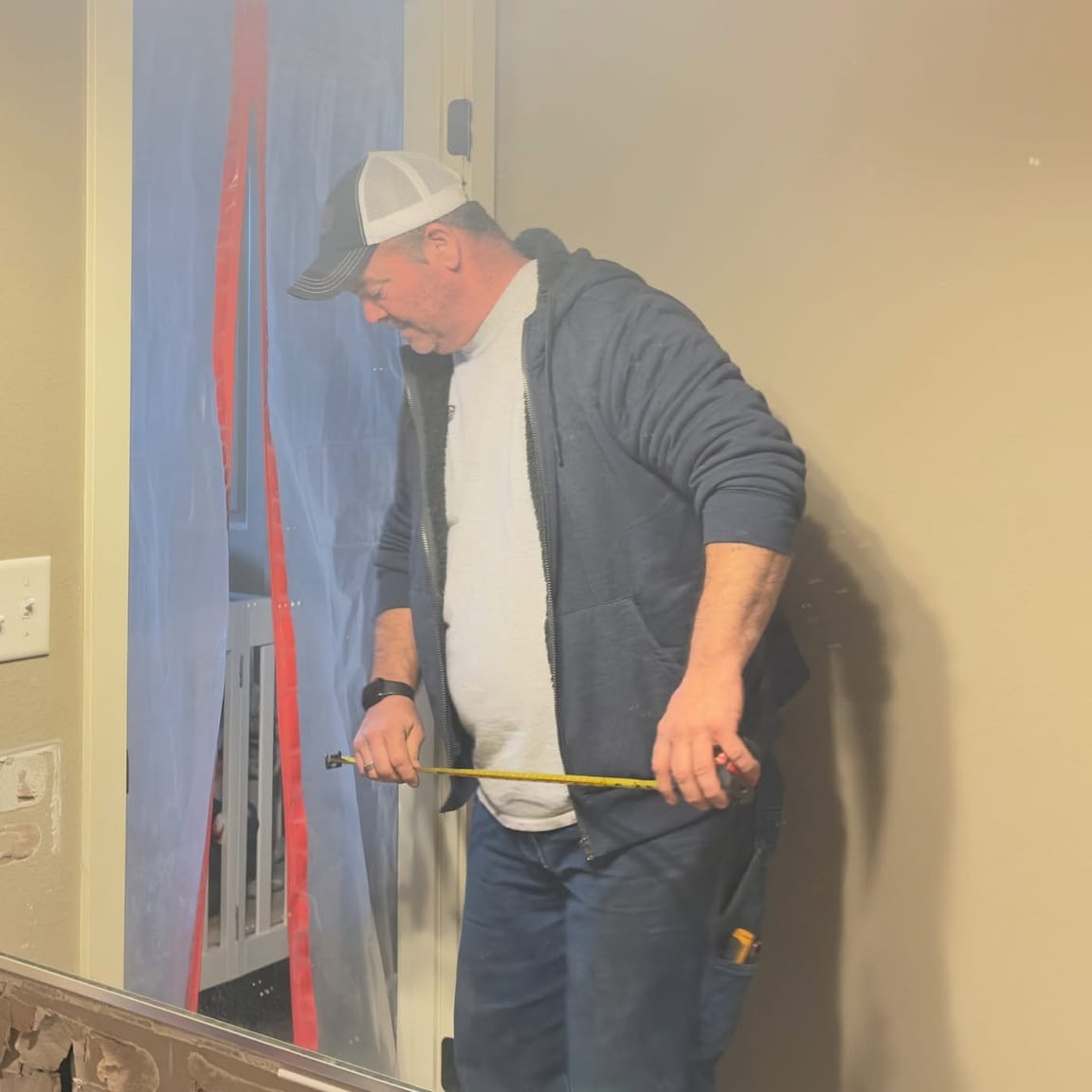 TJ measuring a wall before cutting in a new doorway
