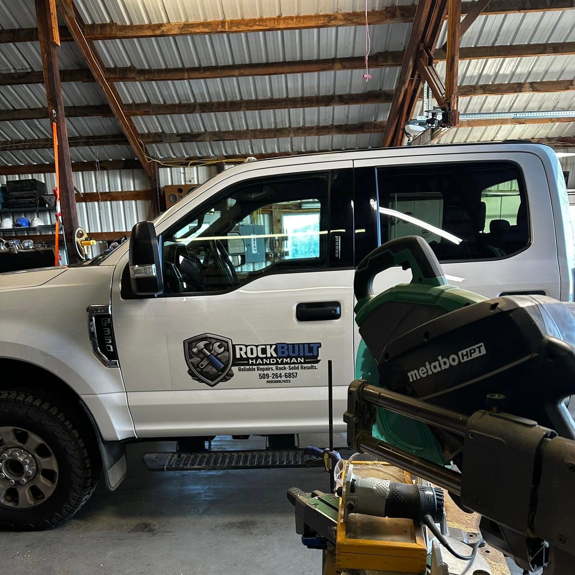 The work truck loaded in the shop beside a miter saw