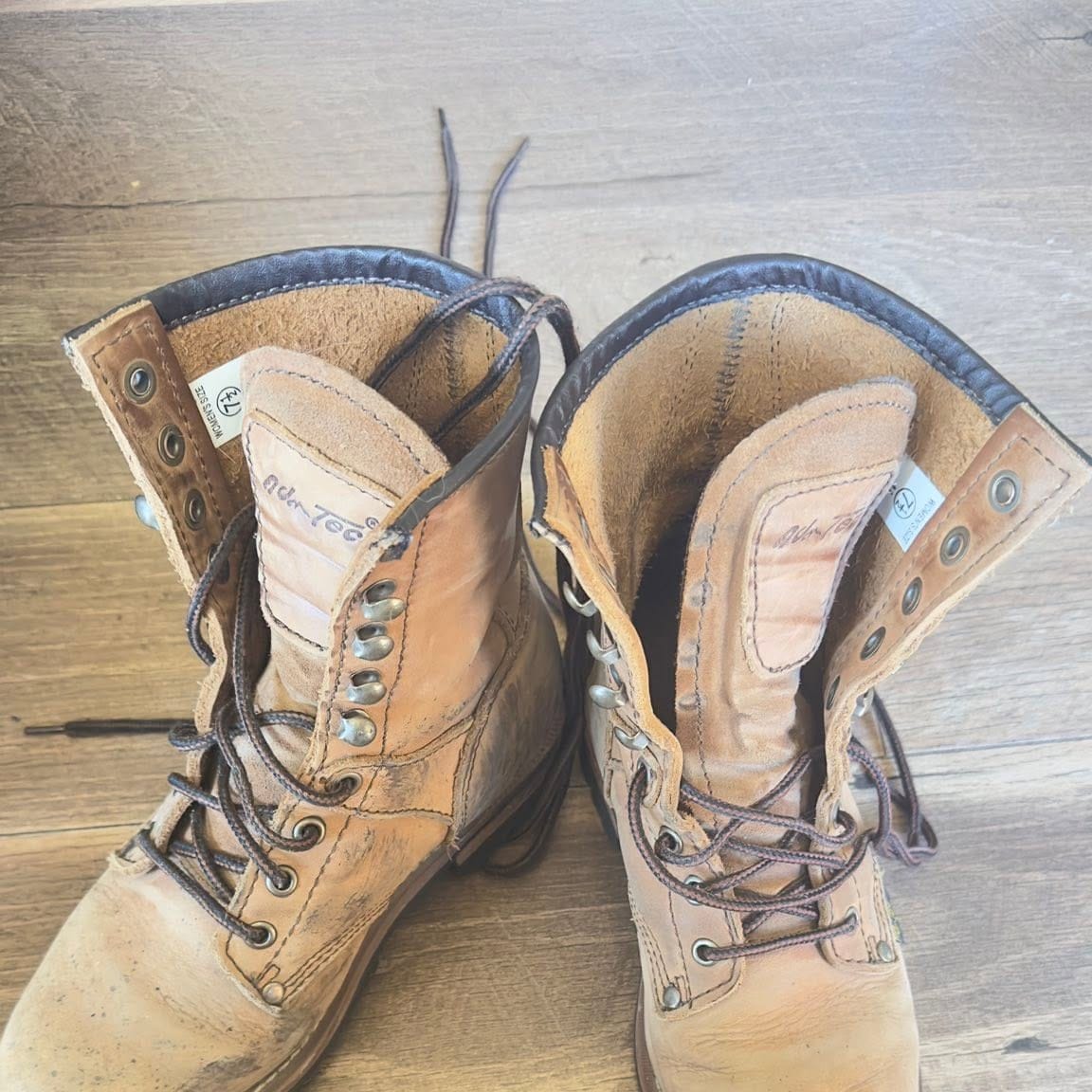 Well worn work boots on a plank floor